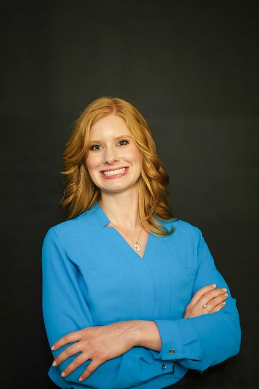 Professional headshot on a dark studio backdrop