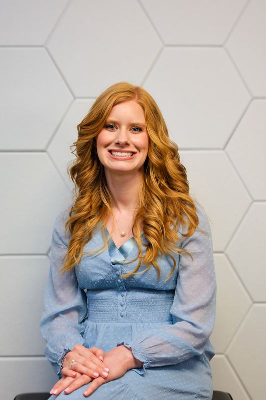 Seated professional portrait on a light backdrop