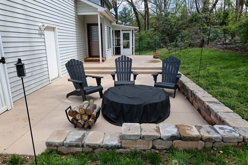 Stone patio with Adirondack chairs around a fire pit