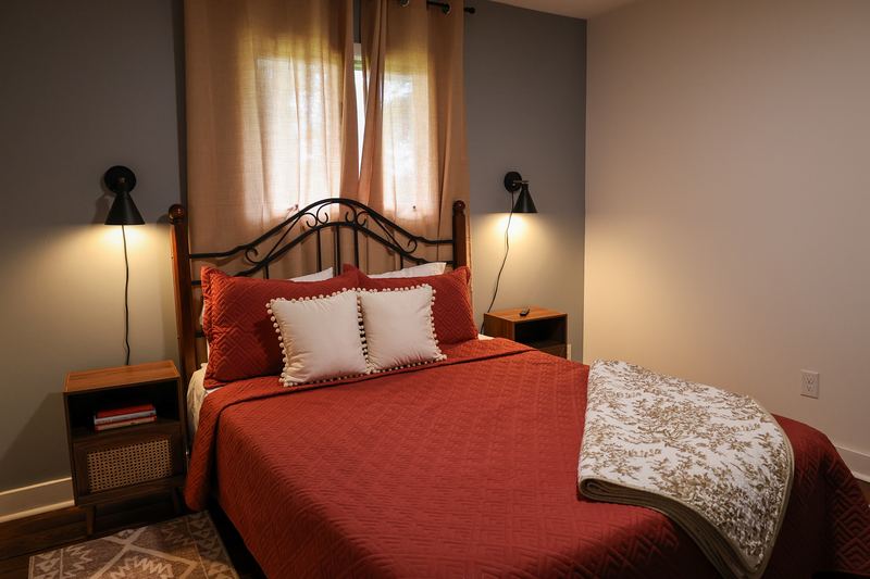 Bedroom with a red bedspread and matching nightstands